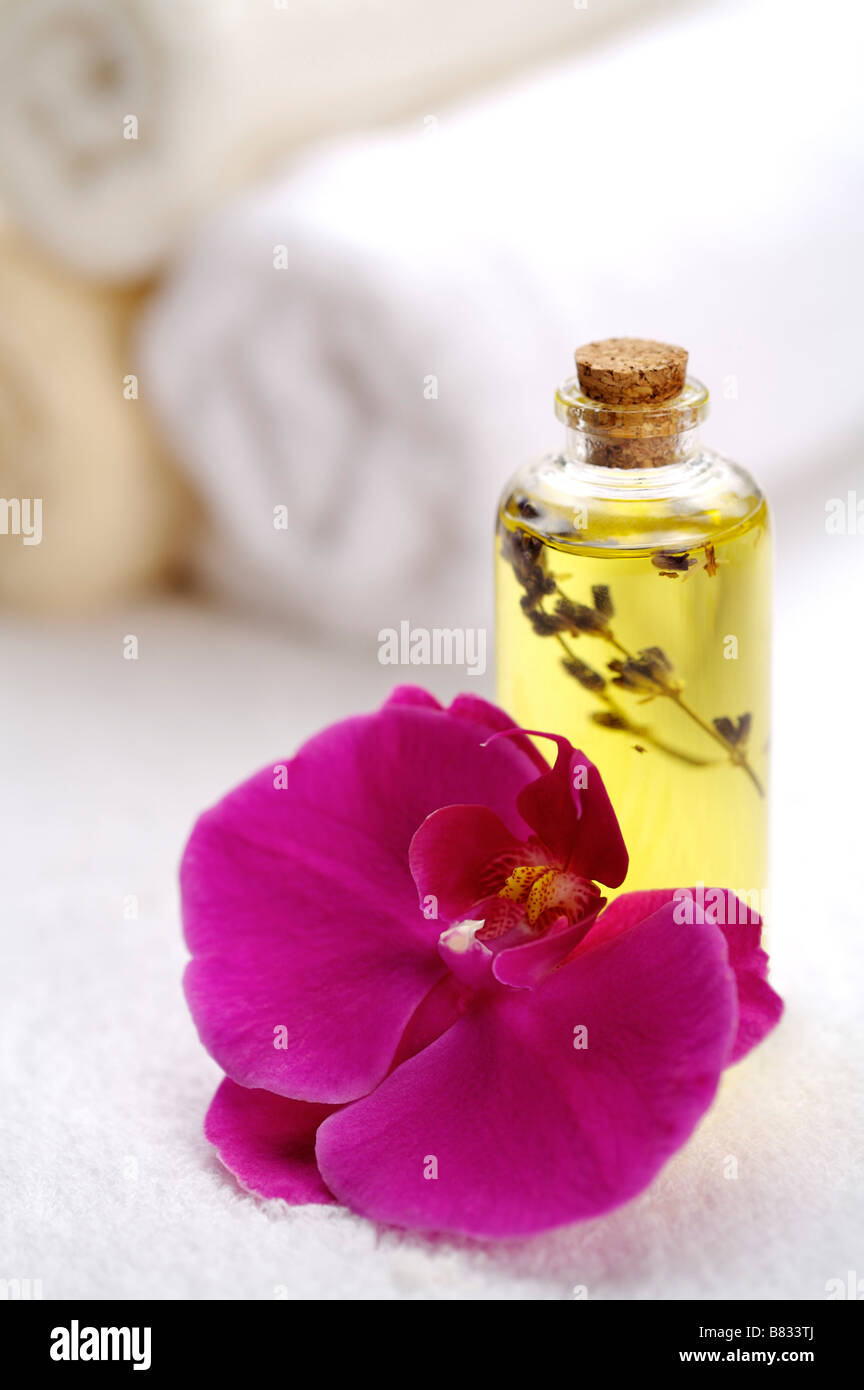 Orchidee und Aromatherapie Öl mit gerollten Handtuch im Hintergrund Stockfoto