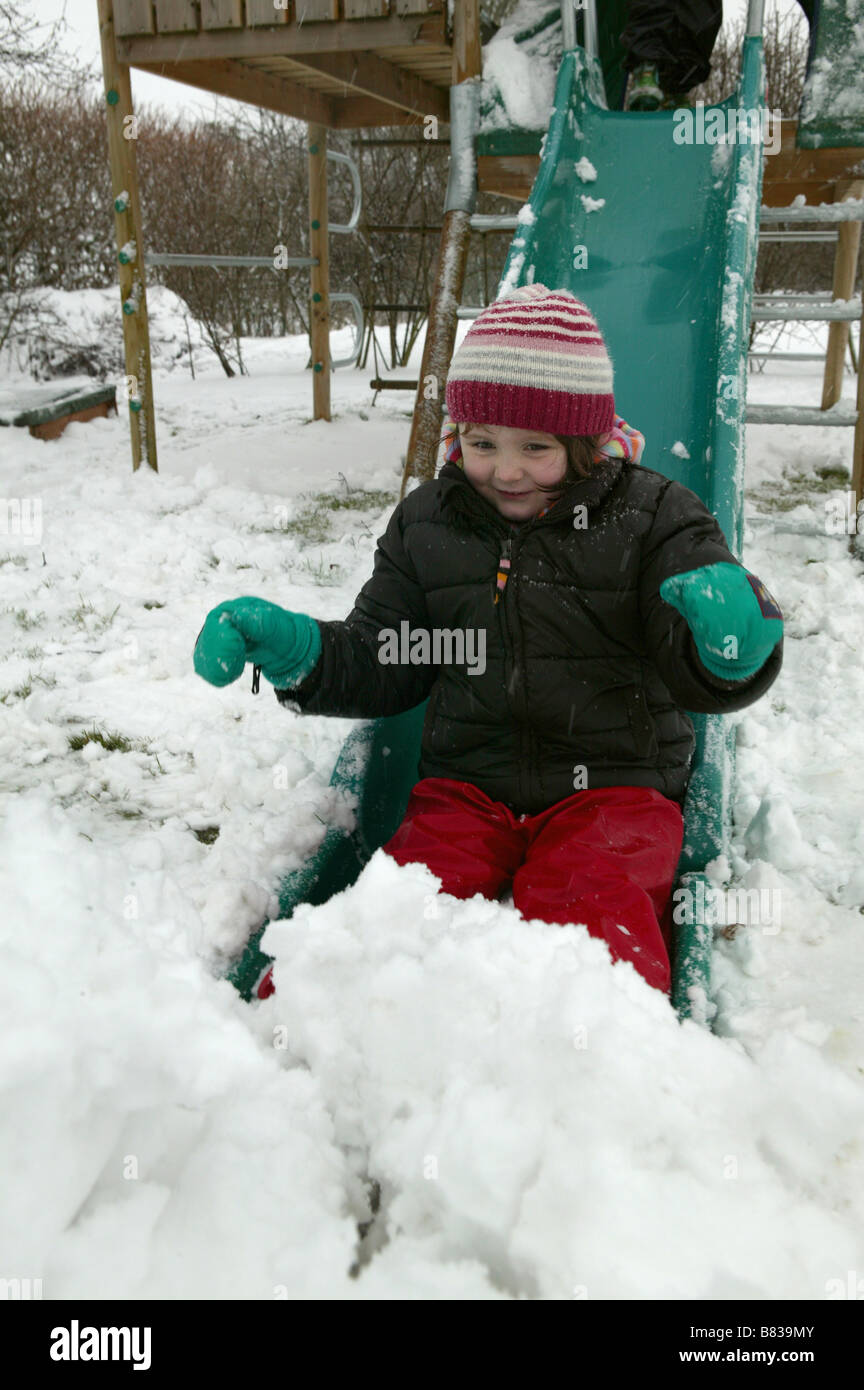 Kinder spielen im Schnee mit einer Folie auf einem Klettergerüst Stockfoto