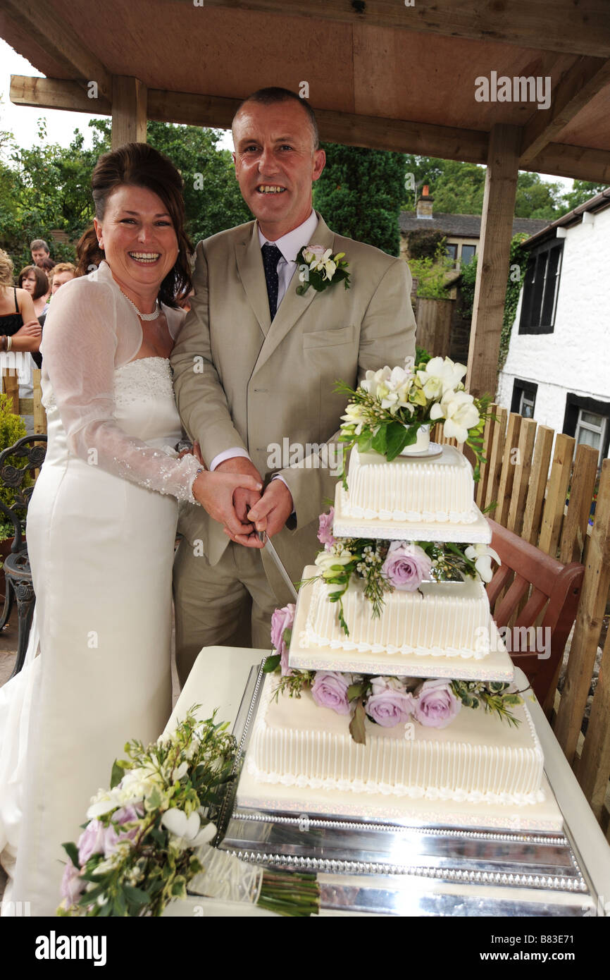 Ein frisch vermählte Paar schneiden ihre Hochzeitstorte, North Yorkshire, Modell veröffentlicht Stockfoto