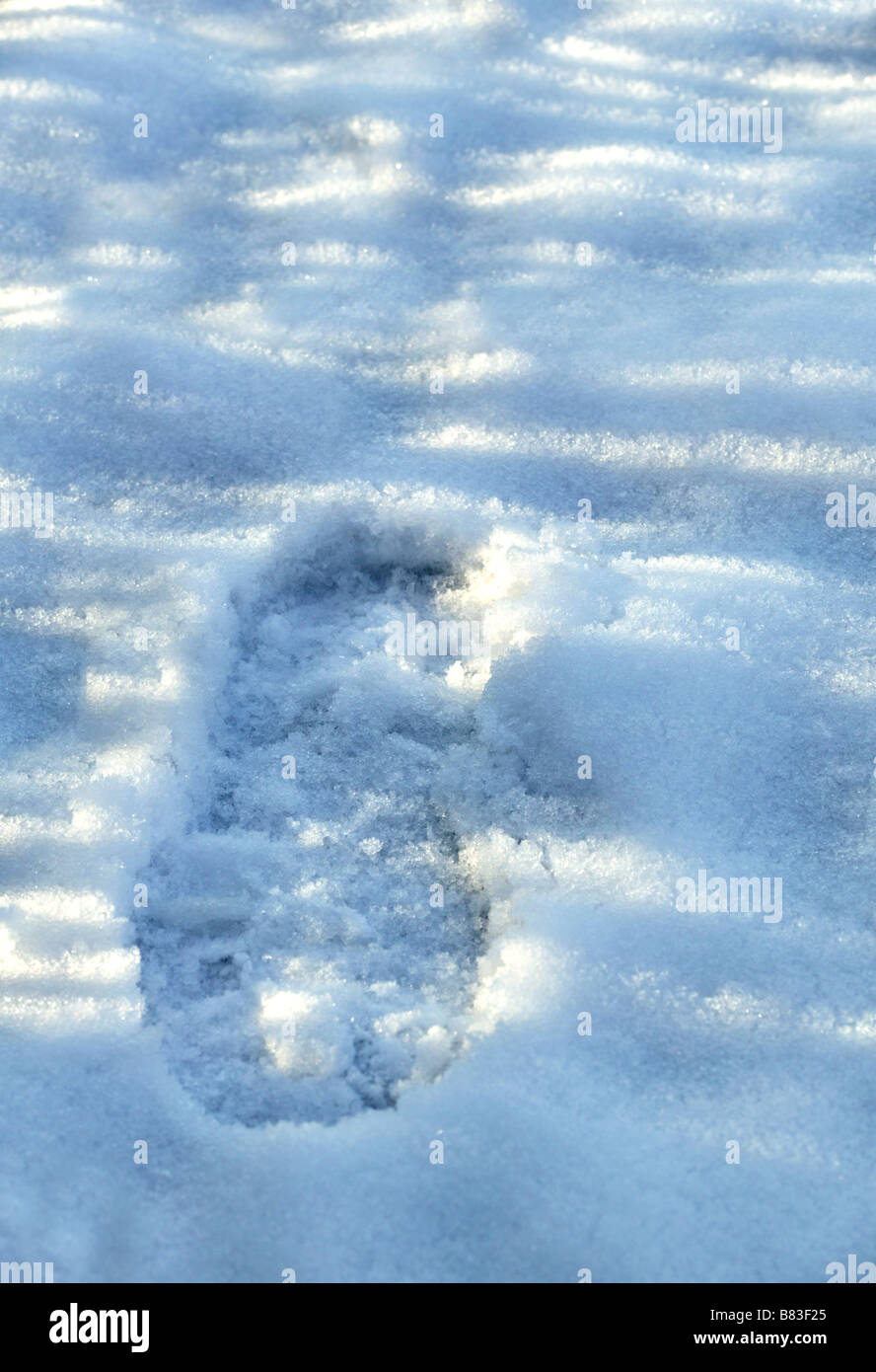ein einzelner Fußabdruck im Schnee mit viel Platz für Kopie Stockfoto