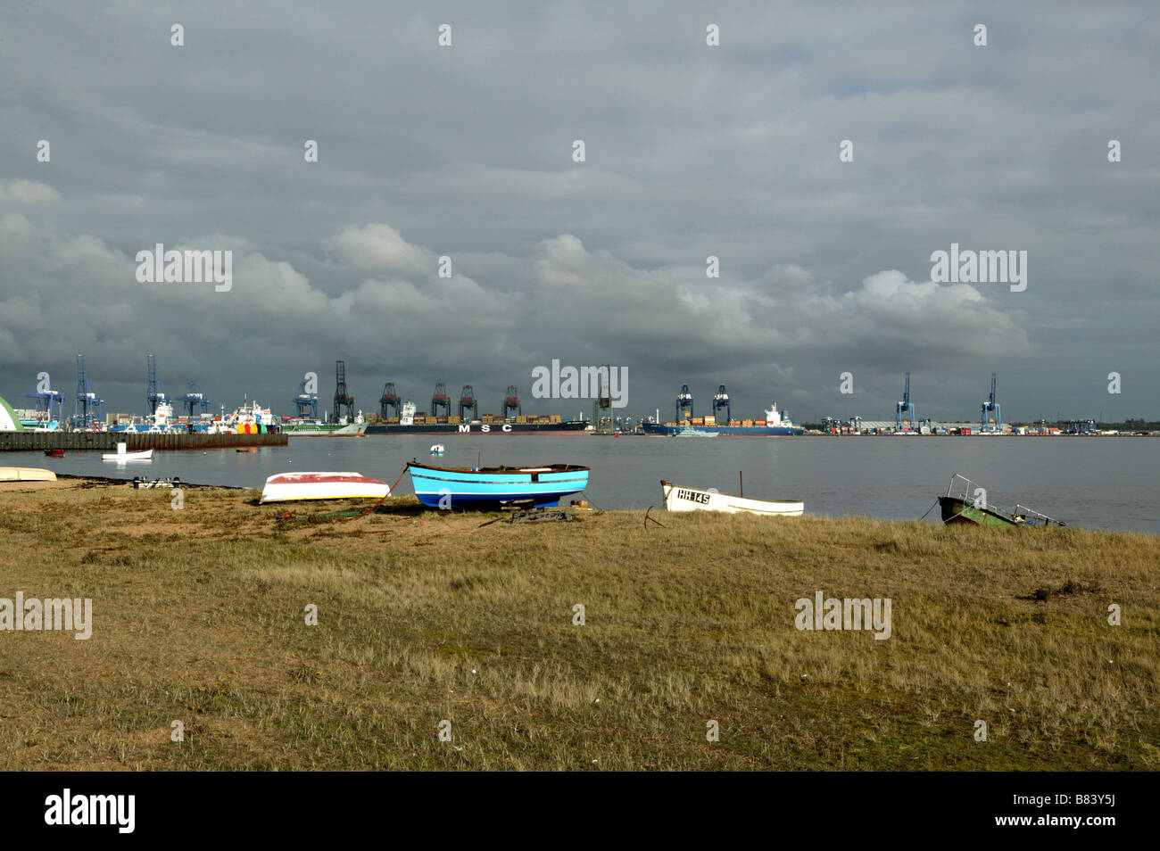 Ein Blick über Harwich Hafen zum kommerziellen Großkrane des Handelshafens mit kleinen Booten auf dem Ufer gezogen Stockfoto