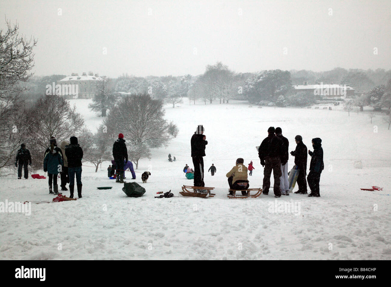 Erwachsene und Kinder genießen den Schnee zusammen in Beckenham Place Park, Lewisham Stockfoto