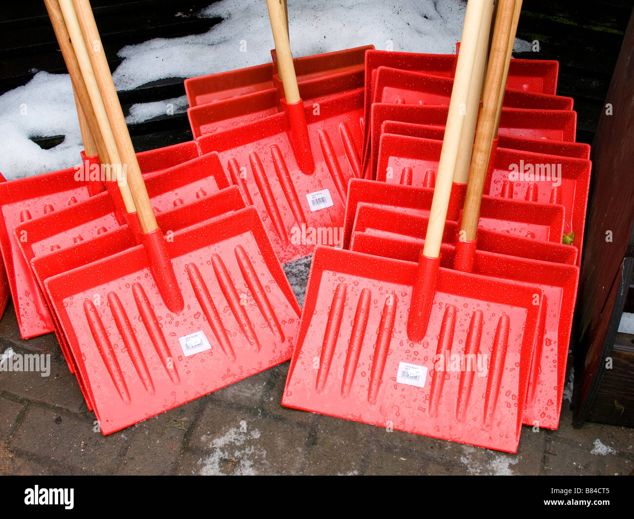 Helle rote Kunststoff Schnee Schaber Schaufeln Schaufeln zum Verkauf Stockfoto