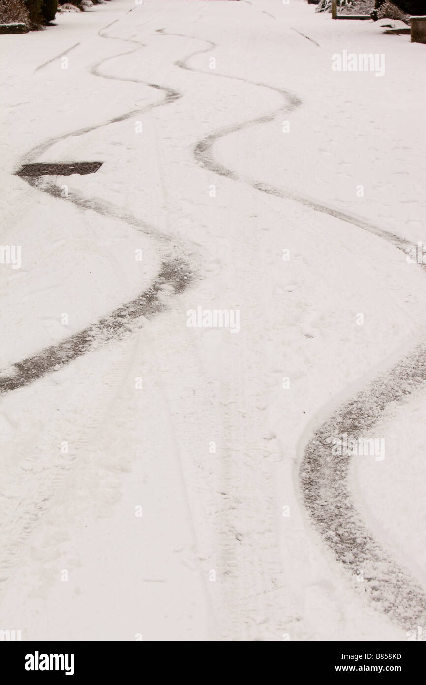 Bremsspuren in den Schnee von einem Auto auf einer steilen Straße in Ambleside UK Stockfoto