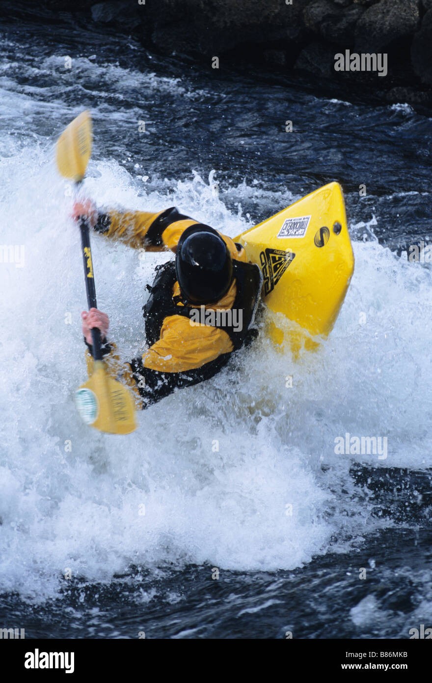 Ein Kajakfahrer spielt in einer Welle auf dem Deschutes River. Stockfoto