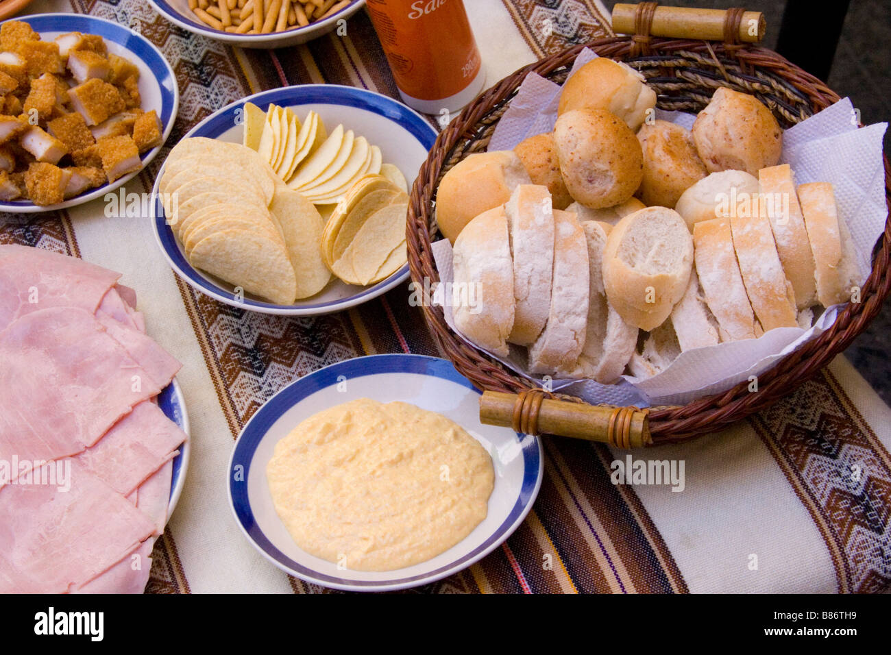 Eine Tabelle mit typischen argentinischen Vorspeisen: Schinken, Brot, einen Brotkorb und Dips. Stockfoto