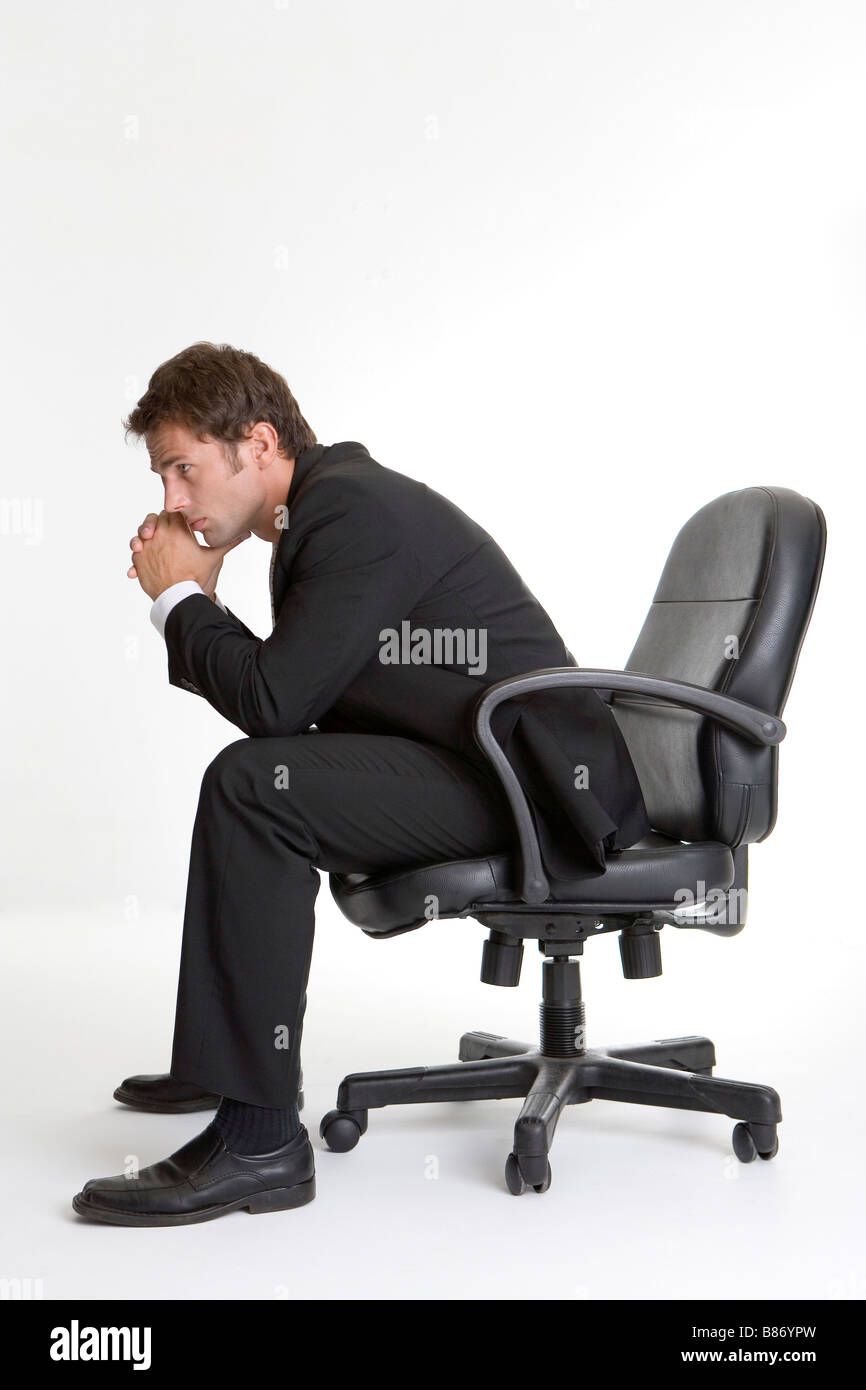 Geschäftsmann auf Stuhl sitzend mit Kinn auf die Hände Seitenansicht Stockfoto