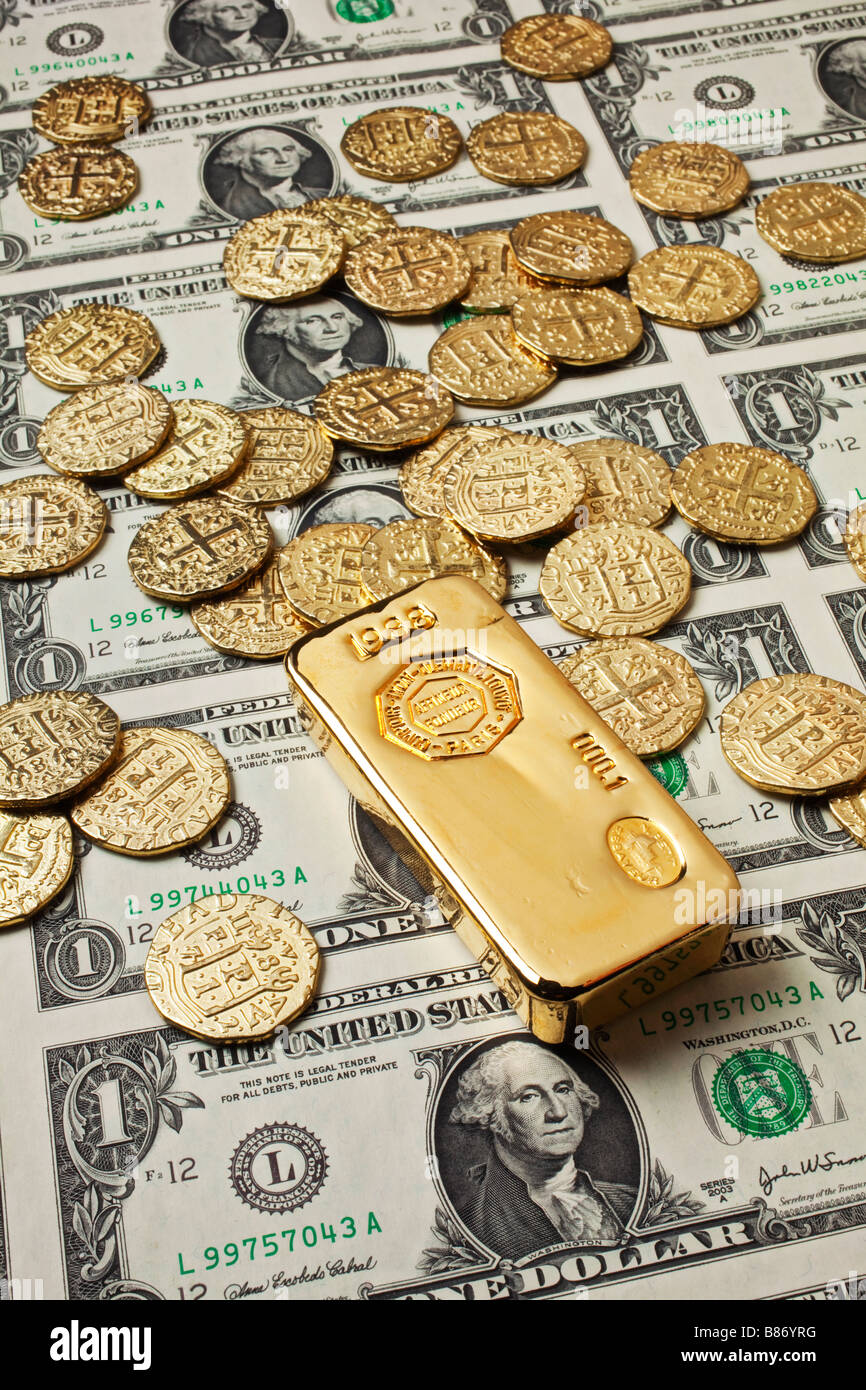 Goldbarren und Münzen auf Dollar-Blatt Stockfoto