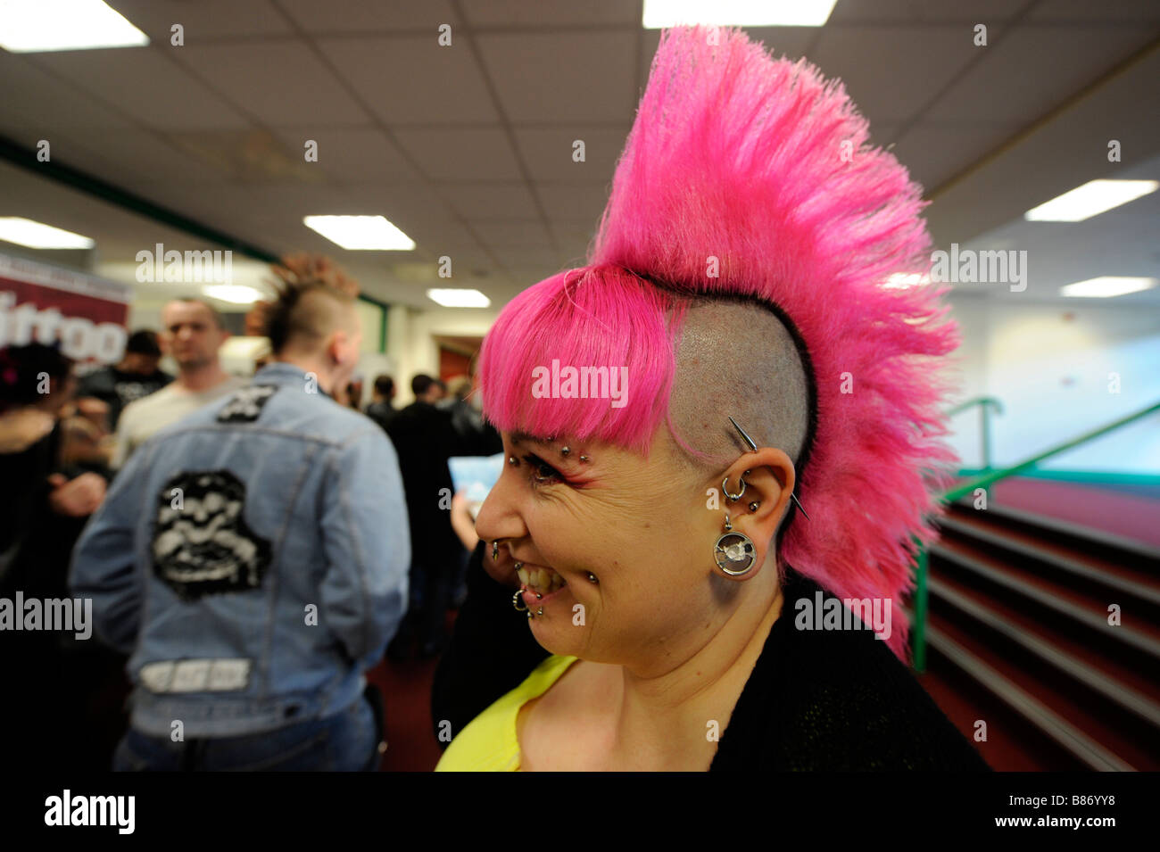 Junge Frau mit leuchtend rosa mohikanischen Haarschnitt auf der Brighton Tattoo Convention Stockfoto