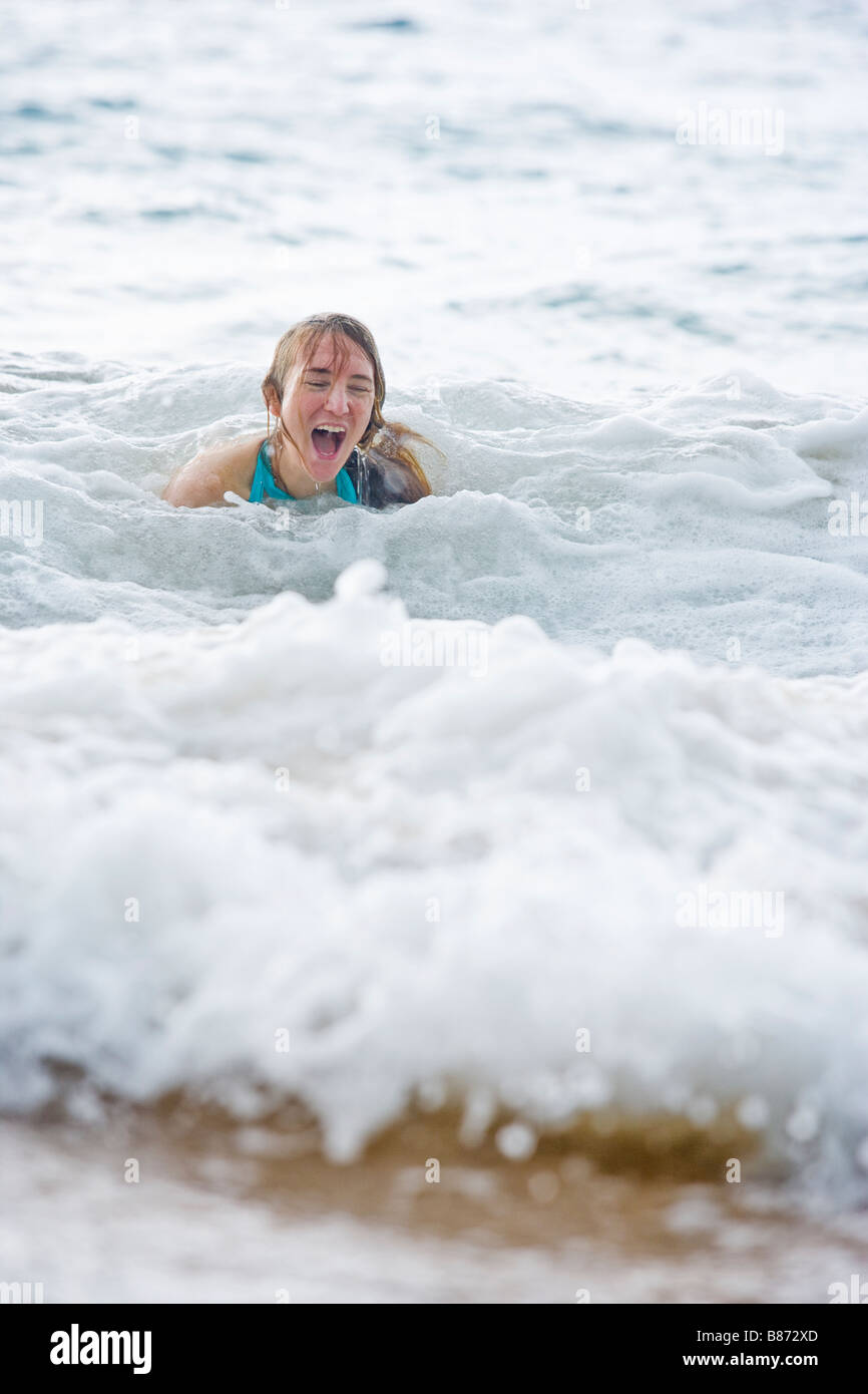 Frau, lachen und Spaß im Schaum einer Welle, die gerade geschlagen und ihr angespült auf Maluaka Beach Maui Hawaii Stockfoto