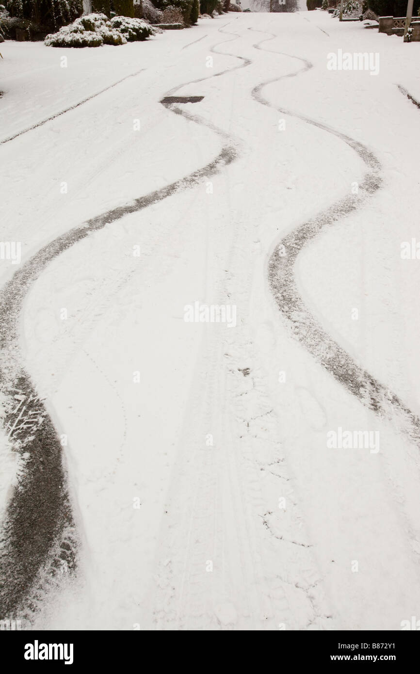 Bremsspuren in den Schnee von einem Auto auf einer steilen Straße in Ambleside UK Stockfoto