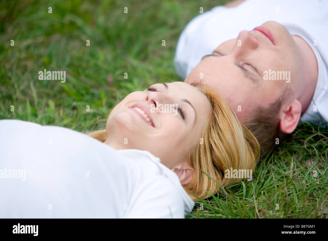 Paar im Rasen Kopf an Kopf liegen Stockfoto
