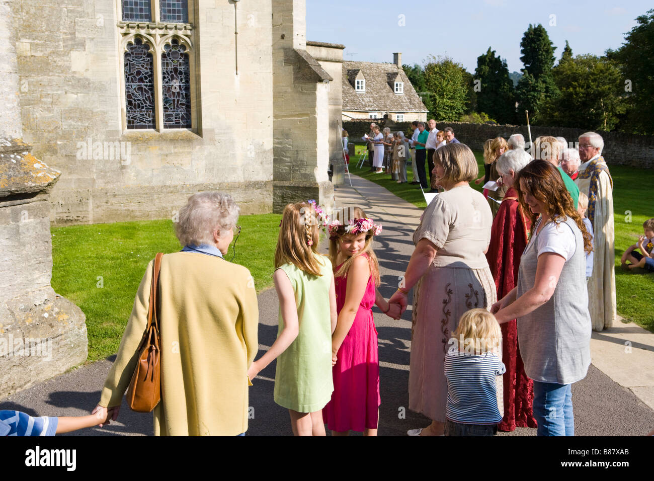 Gemeindemitglieder umschließen die Kirche in den jährlichen Clipping Dienst in Cotswold Stadt von Painswick, Gloucestershire Stockfoto