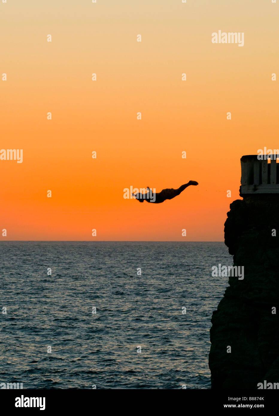 Mexiko MAZATLAN Professional Diver bei Sonnenuntergang tauchen aus einem vier-Geschichte-Plattform namens Punta de Clavadistas (Taucher-Point) Stockfoto