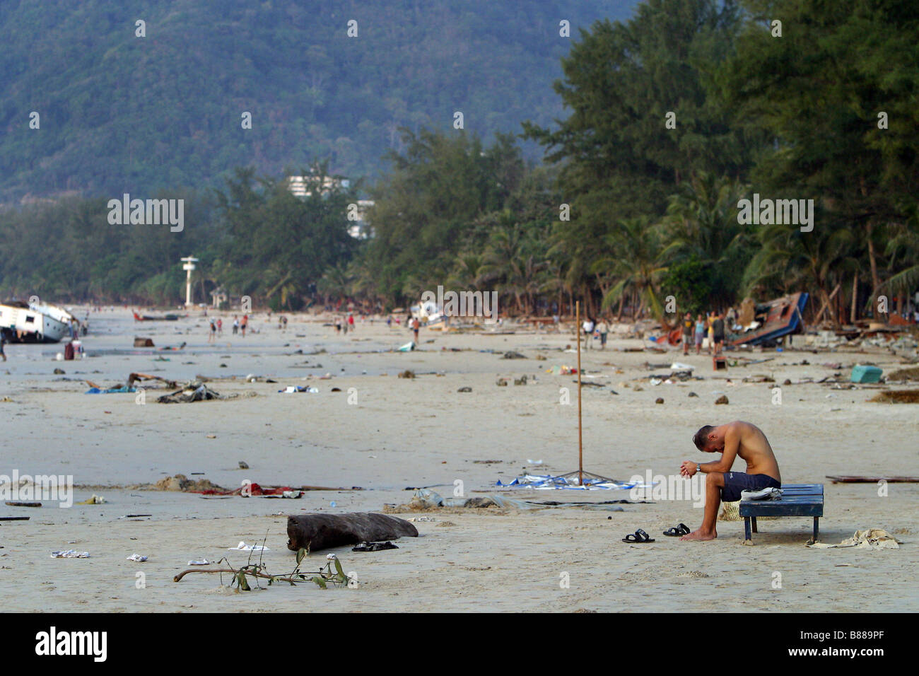 Ein Mann sitzt allein am Patong Beach, Insel Phuket, Thailand am Tag nach dem Tsunami 26. Dezember 2004. Stockfoto