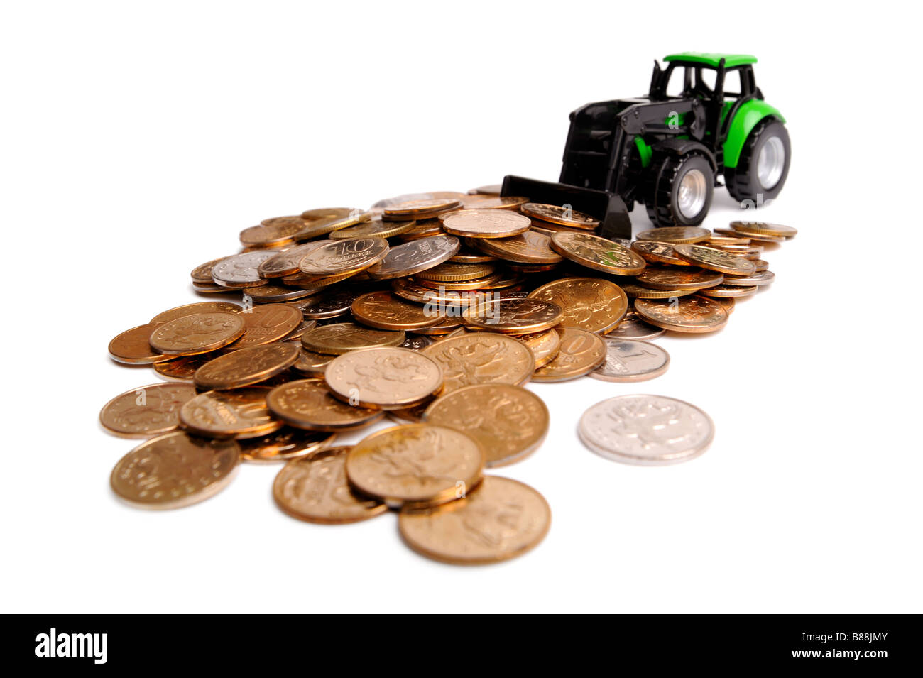 Grüner Traktor Rechen Münzen weißen Hintergrund Stockfoto