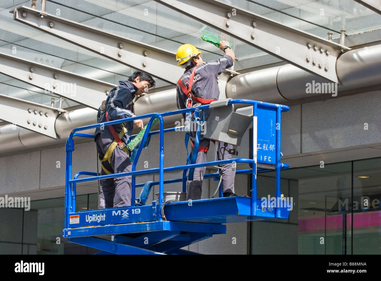 Fensterputzer auf einer erhöhten Scissor-Plattform Stockfoto