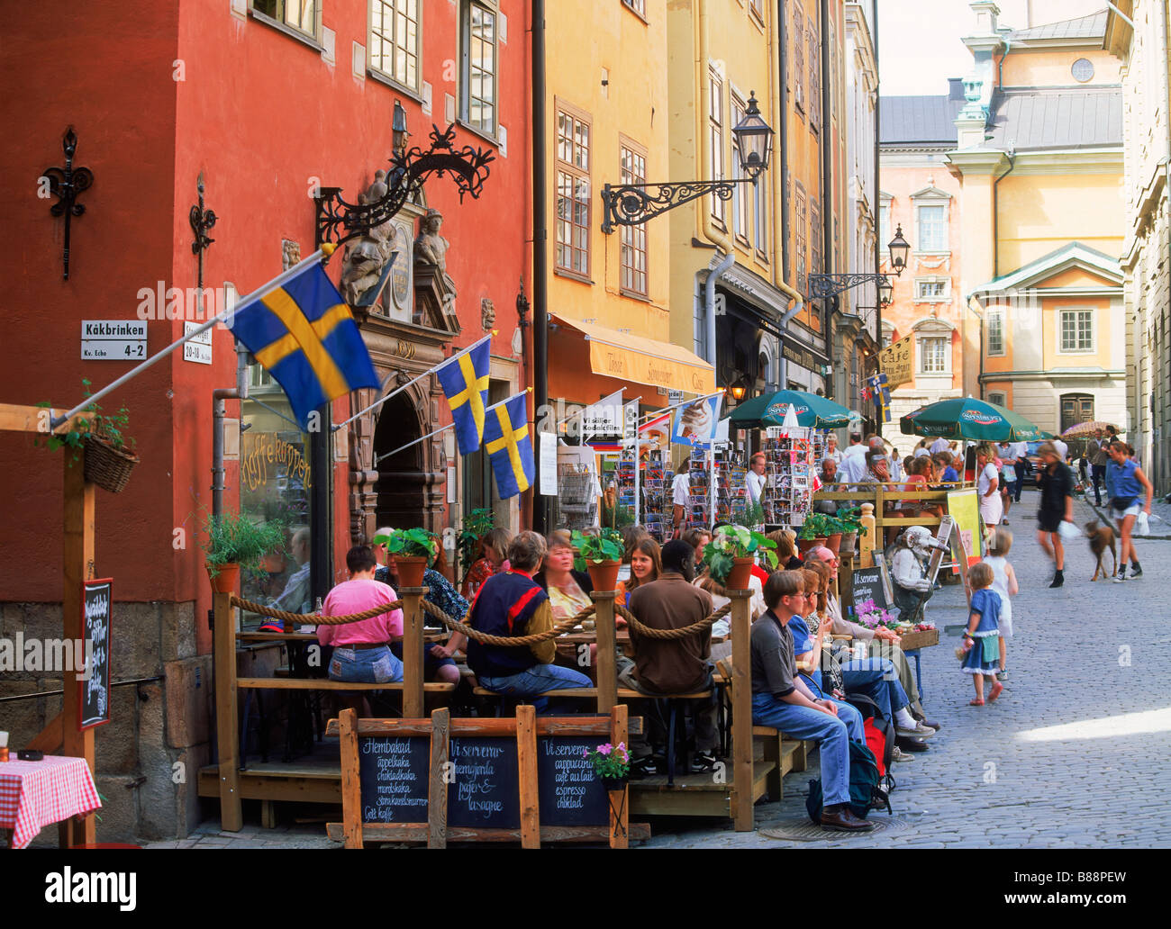 Menschen in Straßencafés und Restaurants am Stortorget Platz in der Altstadt von Stockholm Stockfoto