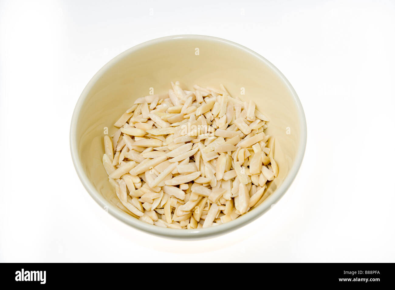 Geschält, geschälten und in Scheiben geschnittenen Mandeln Prunus Dulcis in einer Schüssel auf weißem Hintergrund Stockfoto