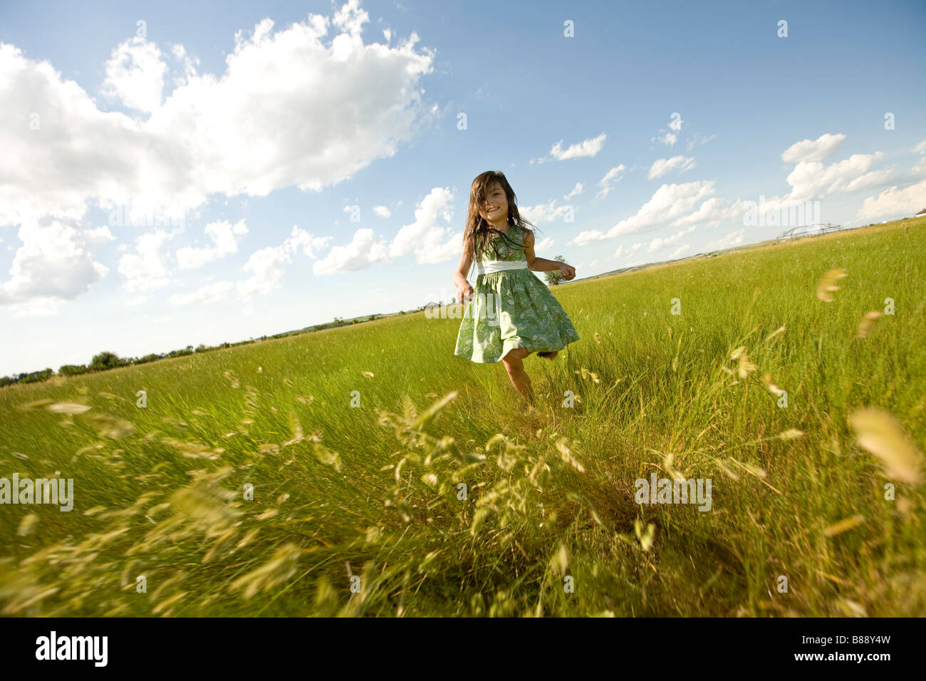 Mädchen läuft über eine Wiese in North Dakota Stockfoto