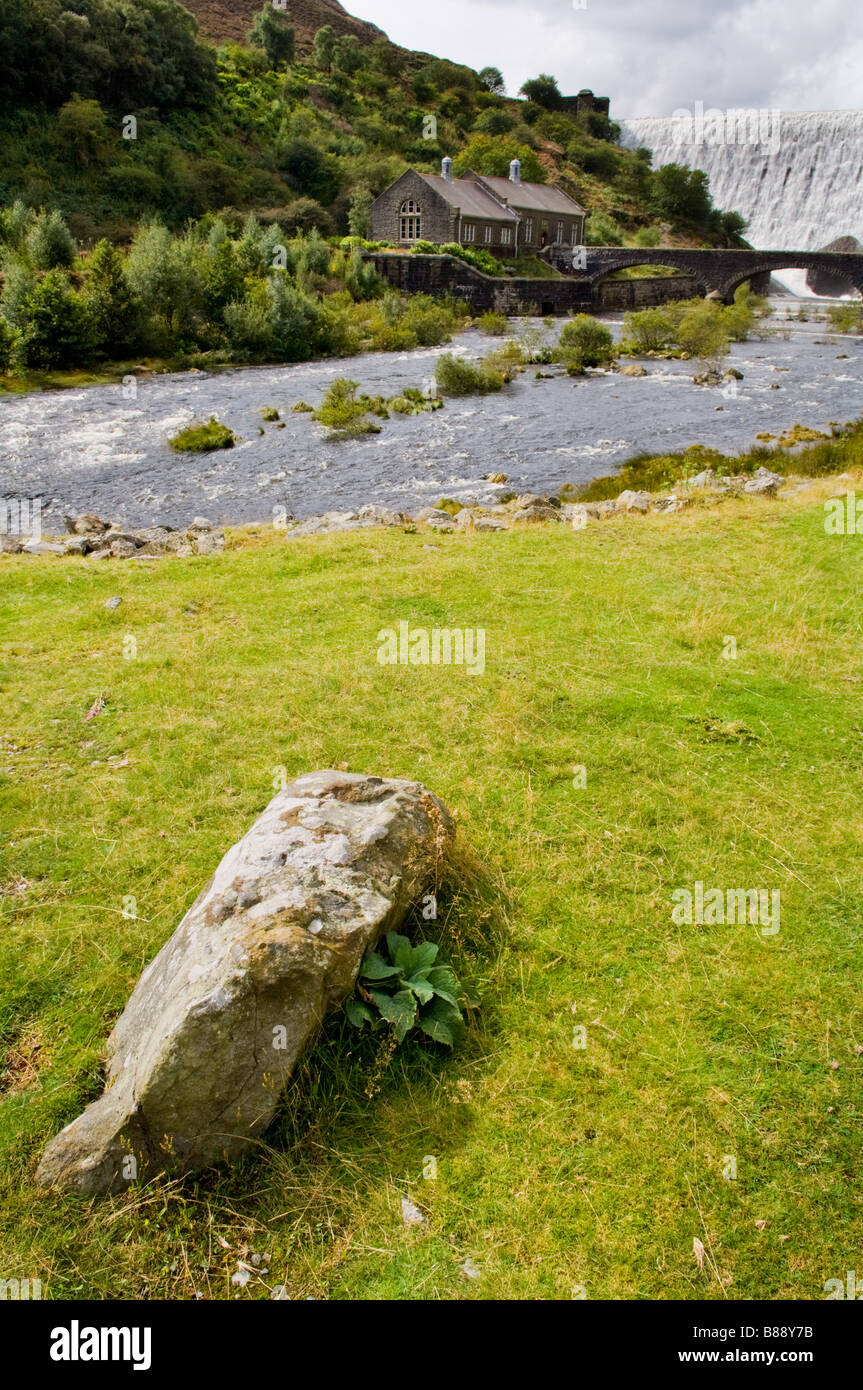 Teil des Elan Valley Besucher Zentrum in powys in Wales mit Caban Coch dam Überlaufen im Hintergrund nach starken Regenfällen. Walisische Landschaft. Stockfoto