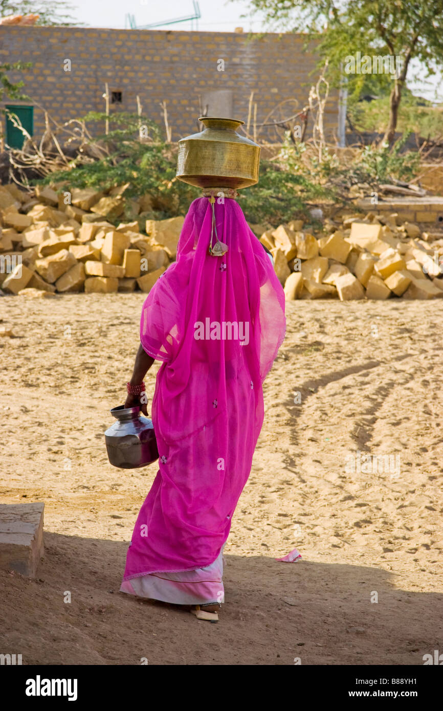 Indische Frau trägt Wassertopf auf Kopf Khuri Wüste Rajasthan Indien Stockfoto