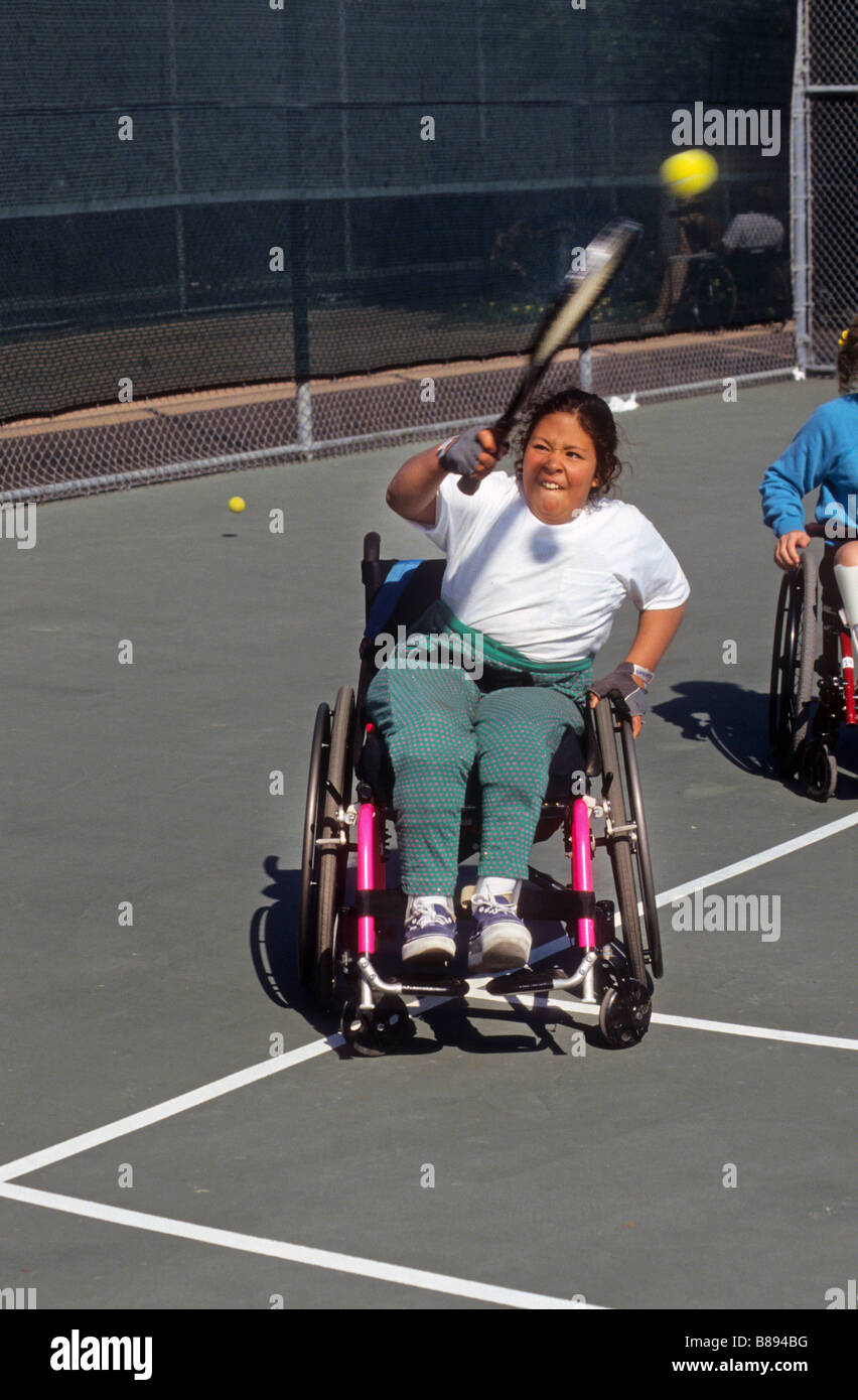 Youngster im Rollstuhl lernt, Tennis zu spielen Stockfoto