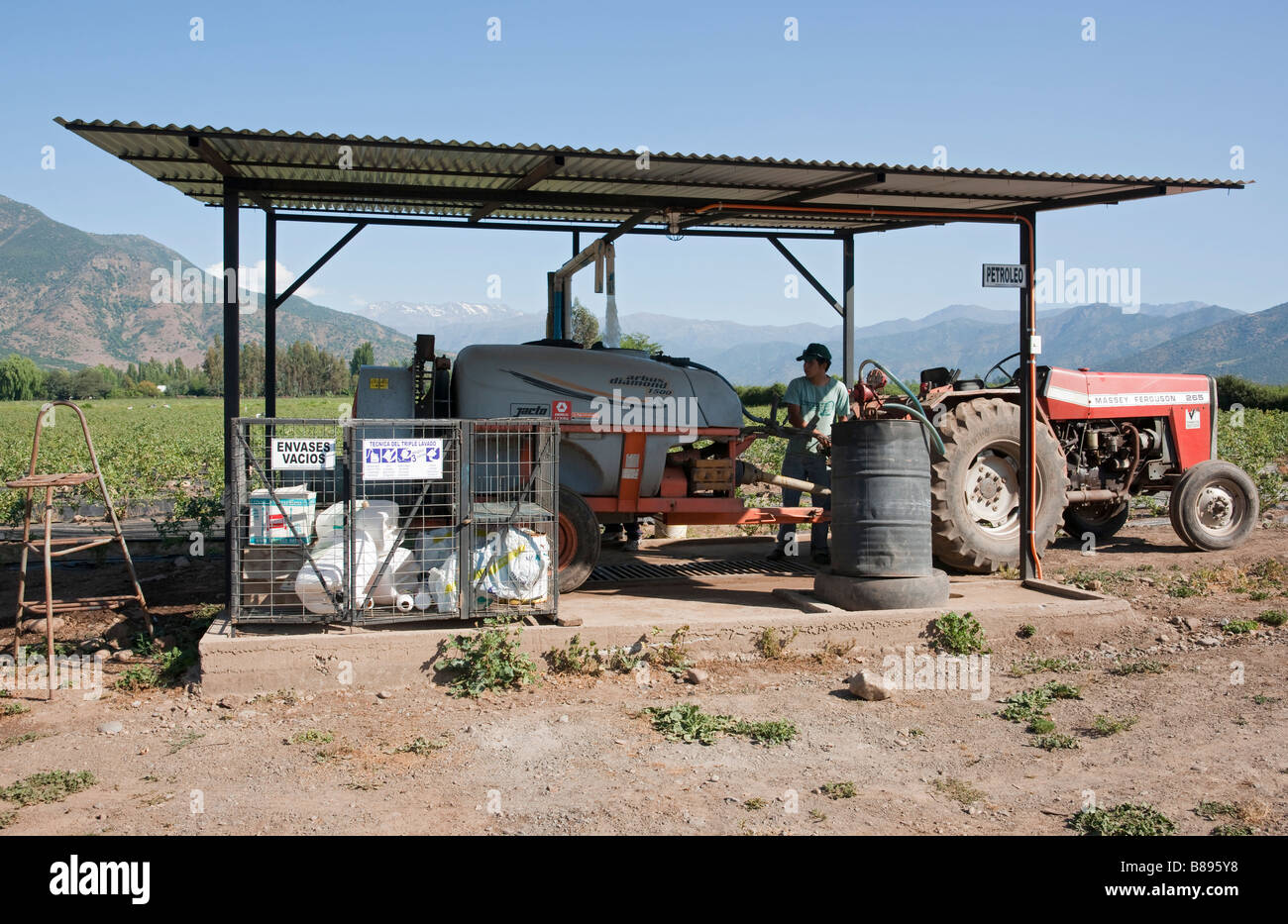 Informiertheitsgefühl Arbeiter Nachfüllen Spritzgerät angeschlossen an einen Traktor, Chile Stockfoto