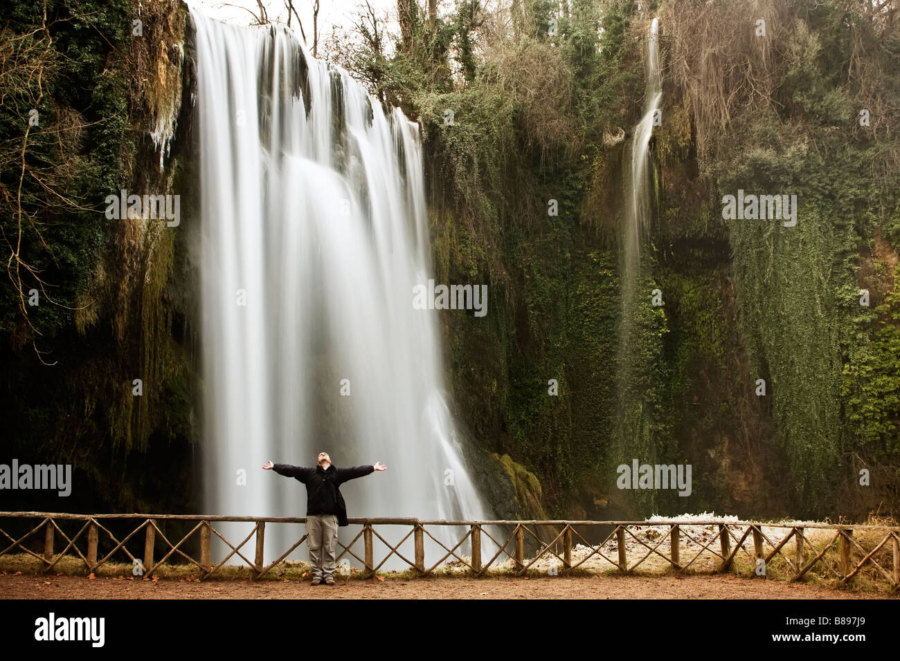 Männlichen Reisenden Gefühl Freiheit unter riesigen Wasserfall Stockfoto