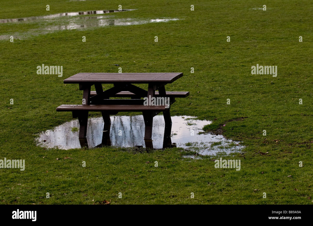 Eine hölzerne Picknick-Tisch in einem überschwemmten Feld. Stockfoto