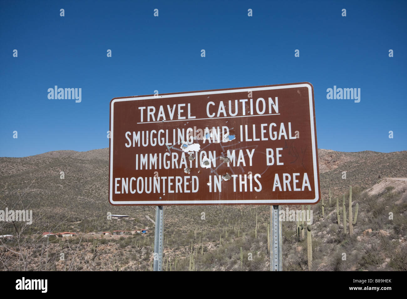 Ein Zeichen in der Nähe von Tucson Az, die liest "Reisen Vorsicht: Schmuggel und illegalen Einwanderung auftreten in diesem Bereich" mit Kugel Stockfoto