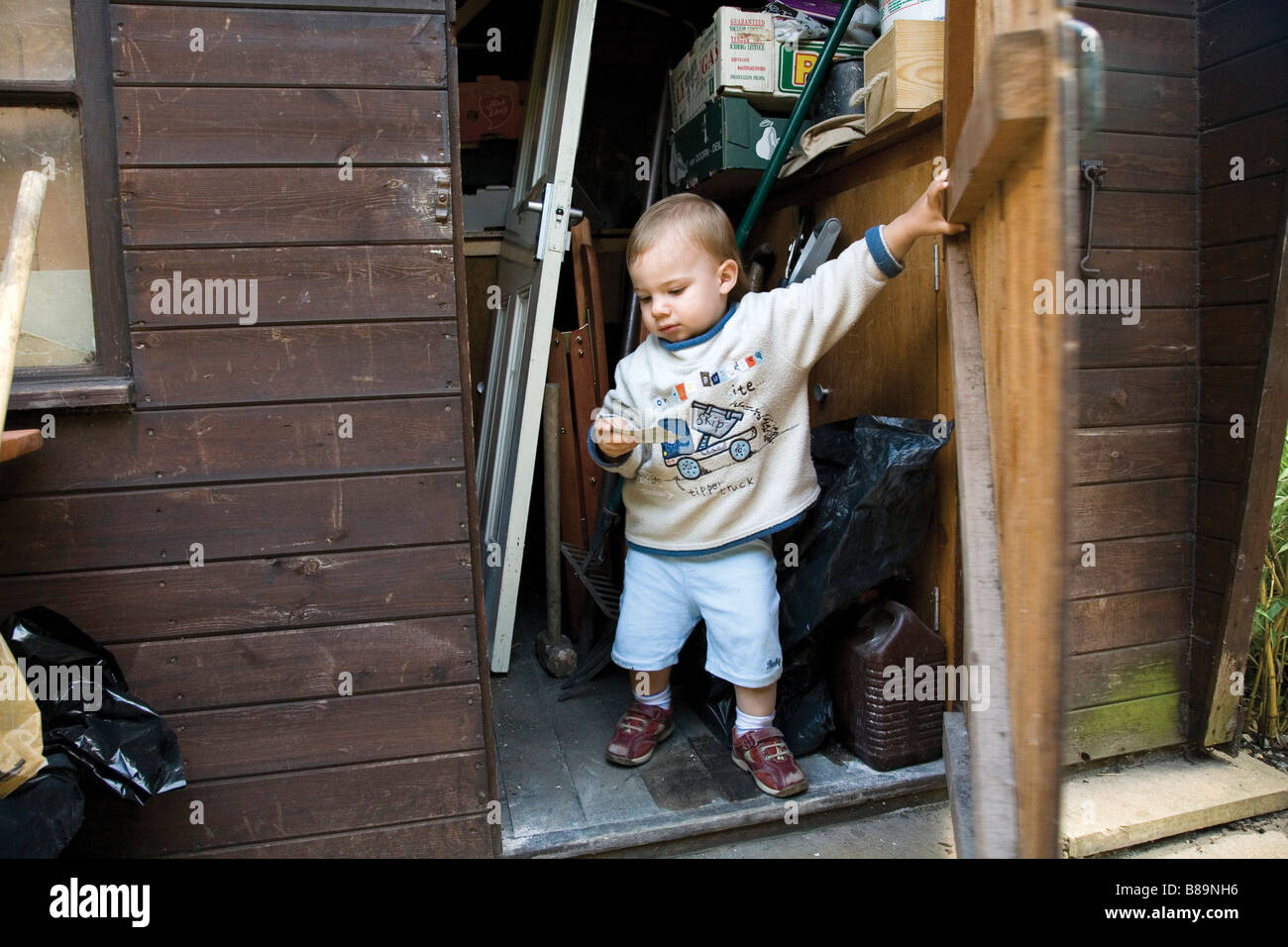 Ernste Junge sitzt in Schuppen Stockfoto