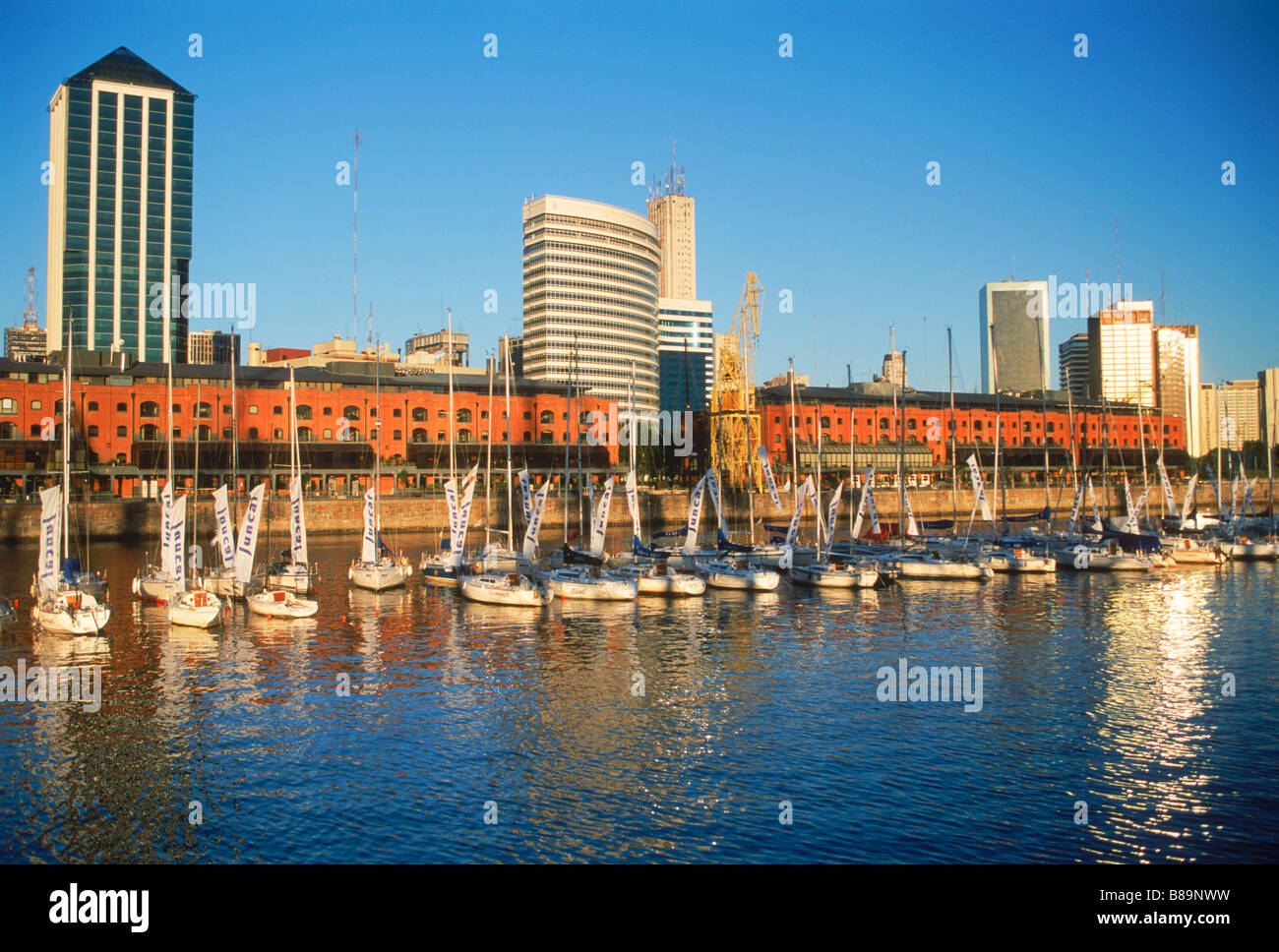 Segelboote, Wohnungen und Bürogebäude am Hafen Puerto Madero in Buenos Aires im Morgengrauen Stockfoto