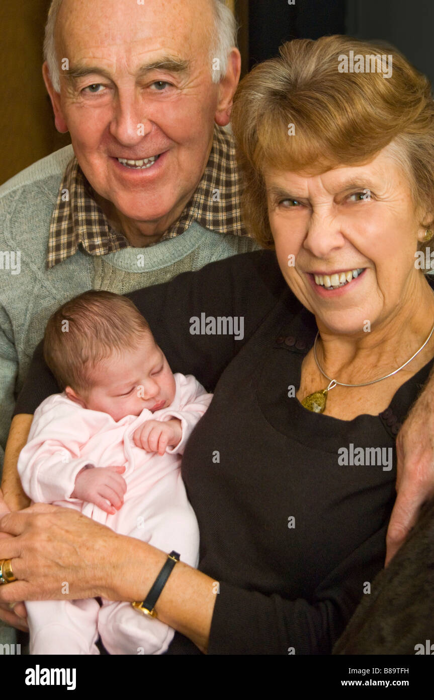 Vertikale Porträt der stolze Großeltern ihre Neugeborene Enkelin kuscheln Stockfoto