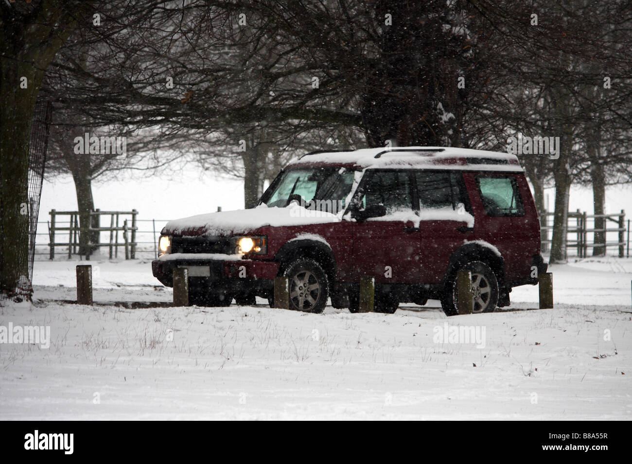 Ein 4 x 4 Landrover Discovery Fahrt durch die Schneestürme an einem kalten Wintertag Stockfoto
