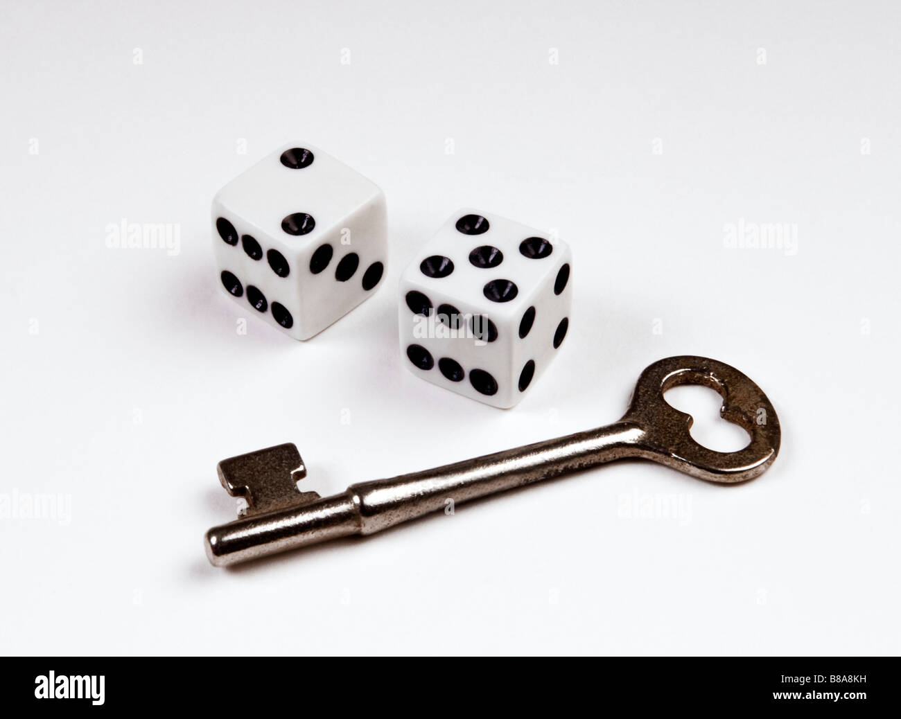 Zwei Würfel und Schlüssel auf weißem Hintergrund Stockfoto