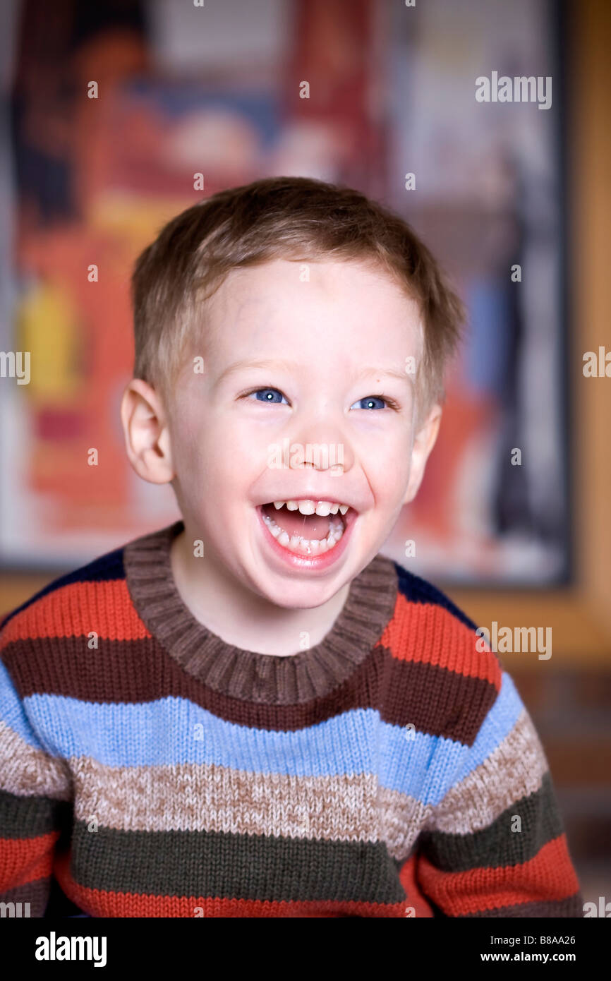 Niedlich fröhlicher Junge mit bunten Pullover Stockfoto