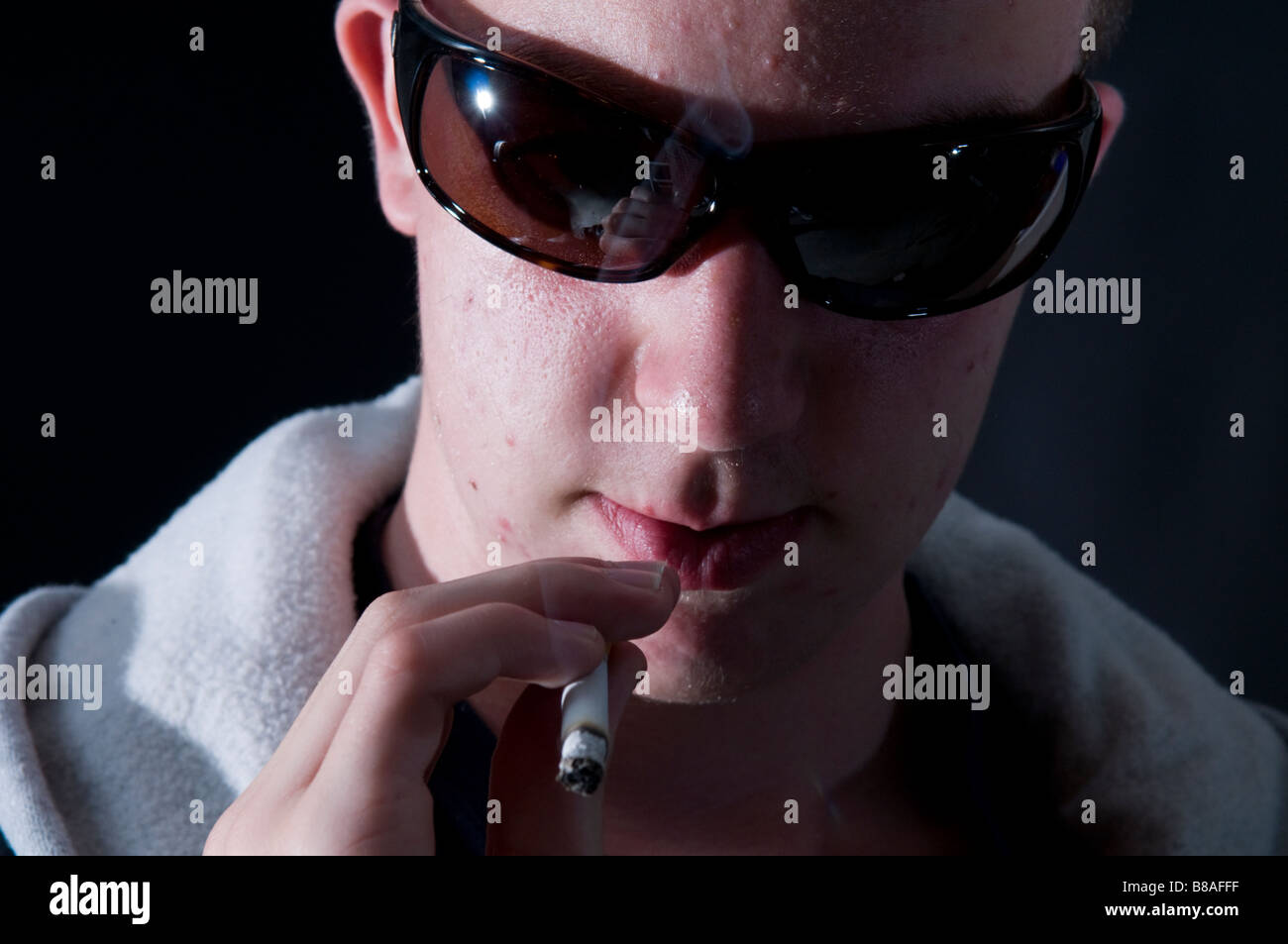 Teenager in Sonnenbrille Rauchen Stockfoto