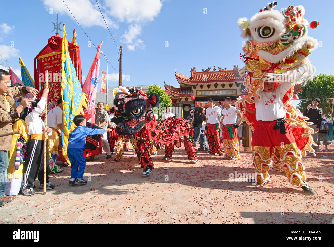 Chinesische Löwen Tänzer während einer Feier und junge Löwen Tänzer einen roten Umschlag geben. Stockfoto