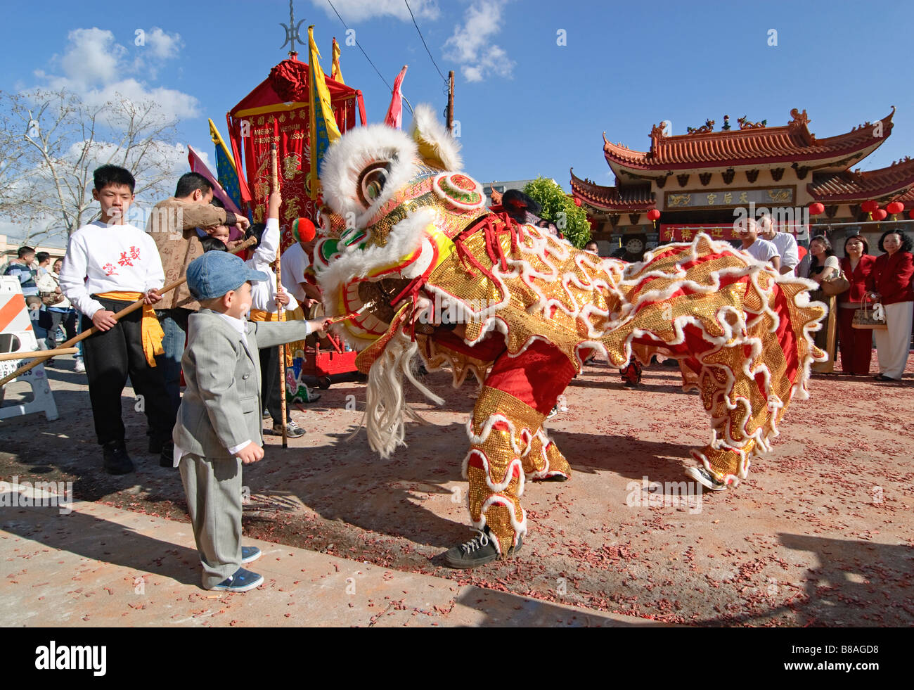 Junge Löwen Tänzer ein rotes Kuvert Geschenk geben. Chinesische Löwen Tänzer während einer Feier. Stockfoto