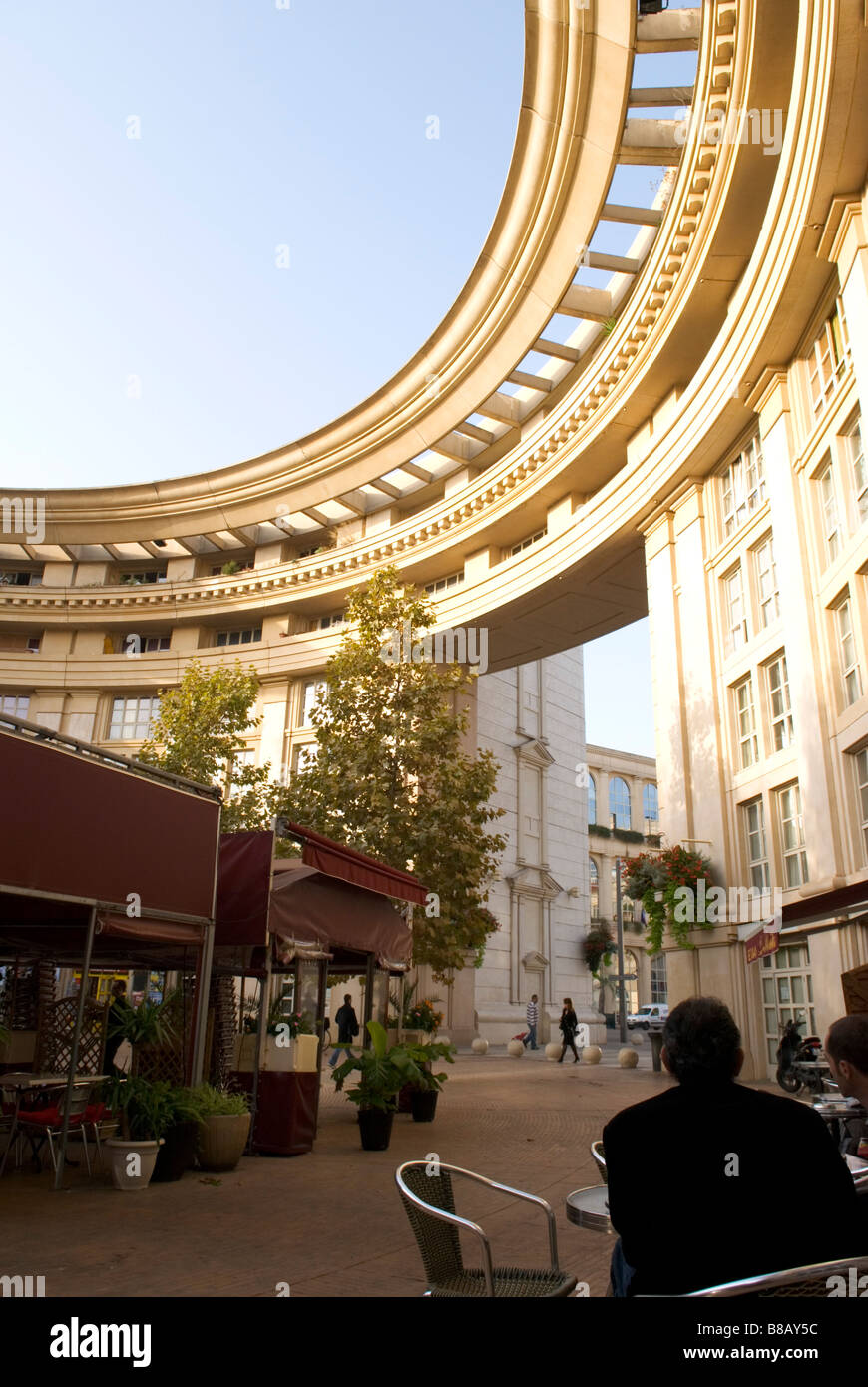 Ein Mann sitzt auf der Café-Terrasse im postmodernen Viertel Antigone, montpellier Stadtzentrum, frankreich Stockfoto