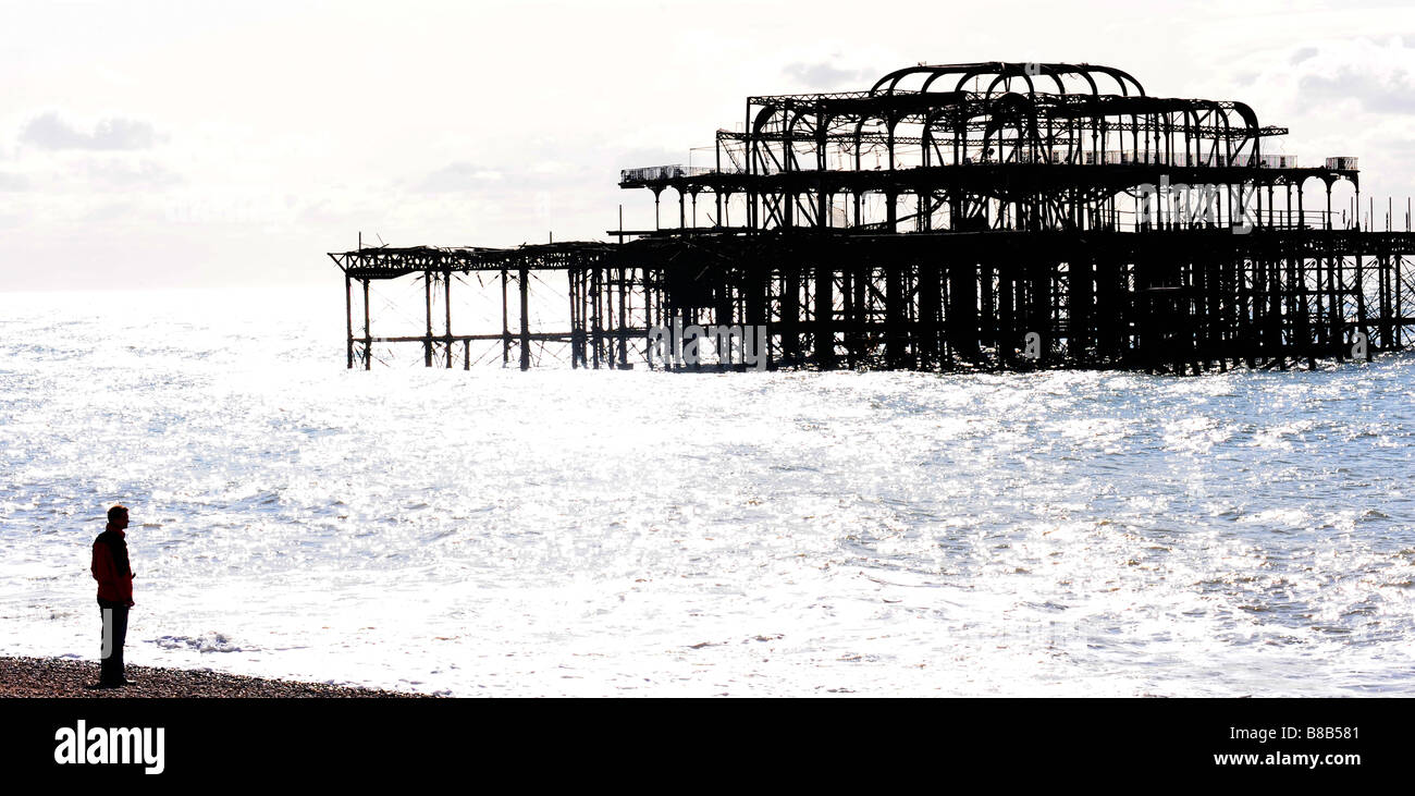 Mann, Blick auf Brightons West Pier Stockfoto