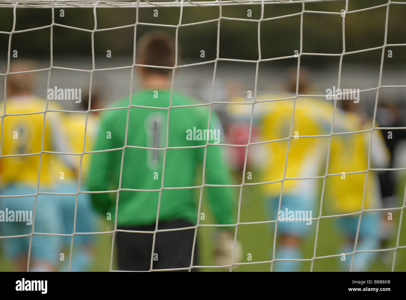 Torwart und Fußballer hinter der Zielfokus Netz Stockfoto