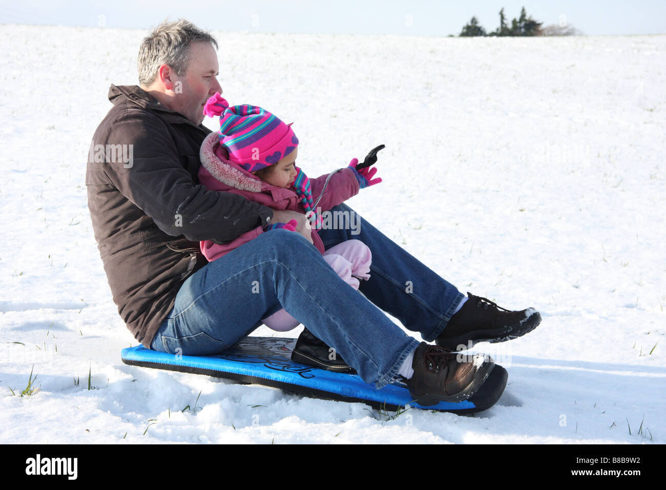 Snowboard Tochter weißen Vater Tochter Toddlerl schwarzen ethnischen Mischlinge glücklich lächelnde Spaß Schnee Eis junge Stockfoto
