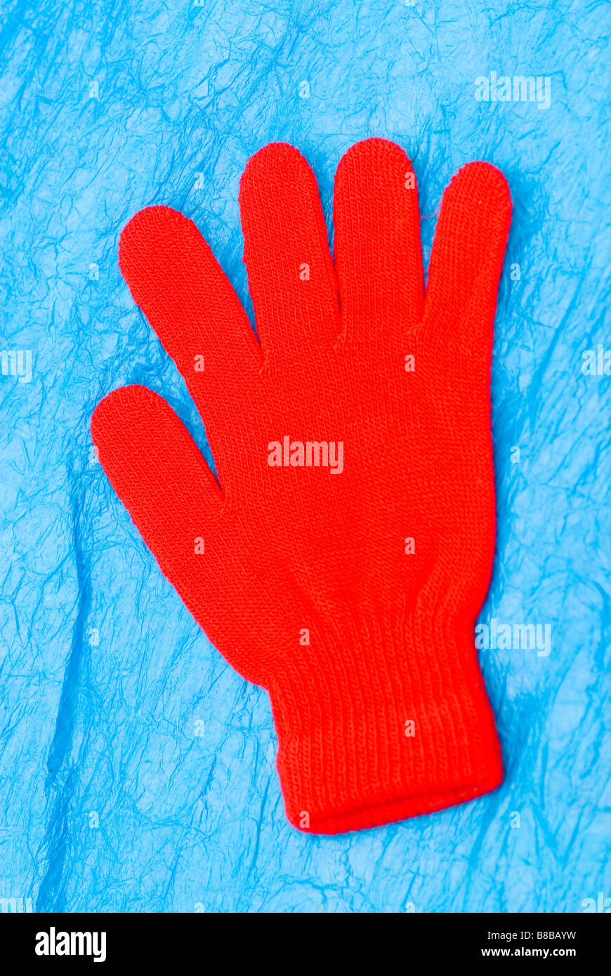 Rot wollenen Handschuh auf blauem Hintergrund Stockfoto