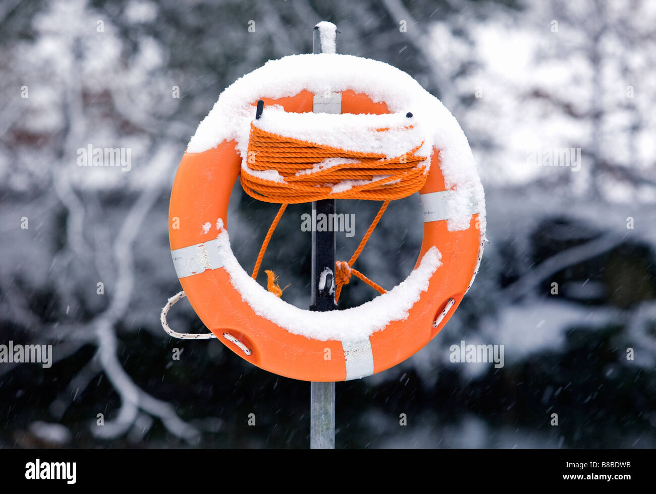 Rettungsring an einem verschneiten Flussufer im Vereinigten Königreich. Stockfoto