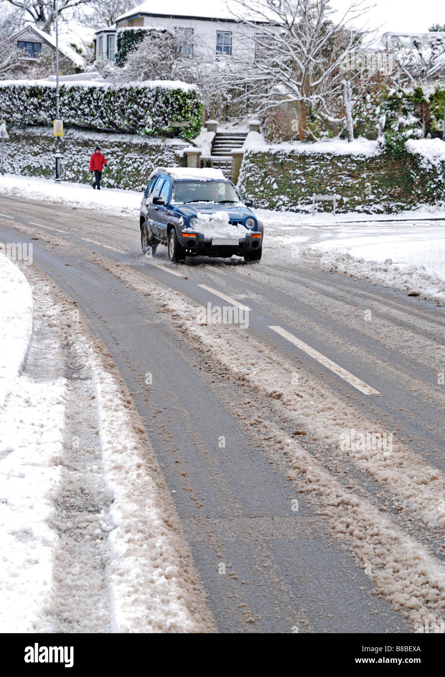 ein Auto sorgfältig durch das Dorf von Chacewater, Cornwall, uk, an einem verschneiten Tag Stockfoto