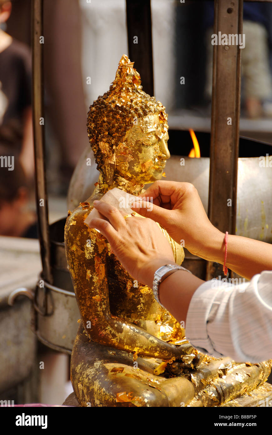 Person, die Anwendung von Blattgold Angebote auf eine Buddha-Statue - Wat Phra Kaew und dem Grand Palace in Bangkok Zentralthailand Stockfoto