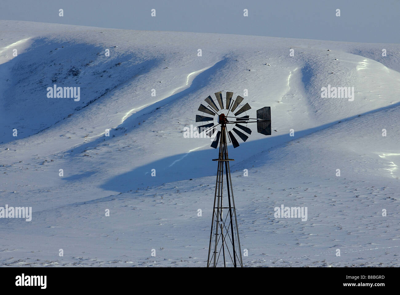 Bauernhof Windmühle Schnee bedeckte Hügel, nahe Walsh Alberta Saskatchewan Grenze Stockfoto