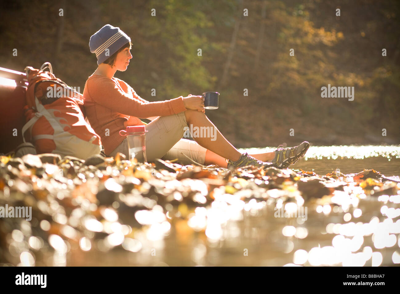 Frau eine Pause und entspannen neben Kanu an einem sonnigen Morgen Stockfoto